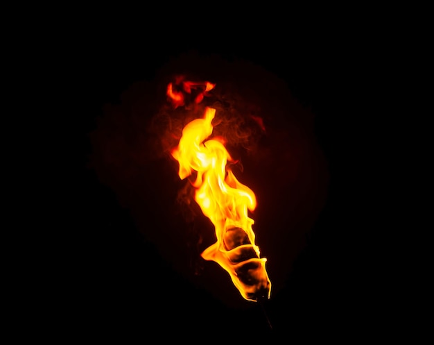 Foto vlam van een fakkel in het donker op een zwarte achtergrond, alleen het vuur is zichtbaar