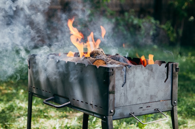 Vlammende barbecuegrill in de tuin in zomer