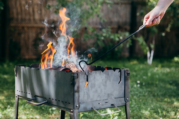 Vlammende barbecuegrill in de tuin in zomer