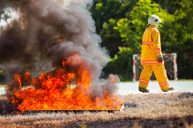 Vlamvuurbewegingen en brandweerman met pak om brandweerman te beschermen