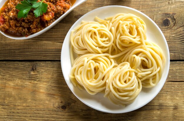 Vlees Bolognese saus met spaghetti op een houten tafel