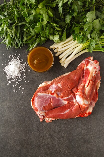 Vlees en groene groenten voor het koken van chakapuli, een Georgisch traditioneel gerecht.