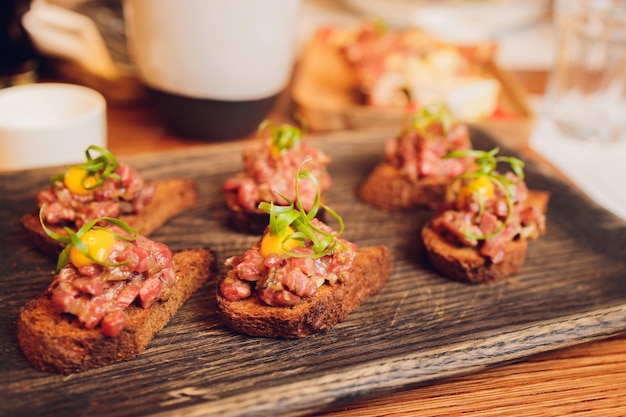 Vlees op gesneden stokbrood kleine sandwiches aan boord smakelijke maaltijd in italiaans café bewezen recept van bruschetta