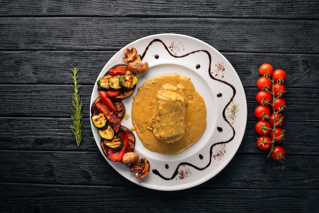 Vlees steak met saus en gegrilde groenten Steak Voronov Op een houten achtergrond Vrije ruimte voor uw tekst Bovenaanzicht