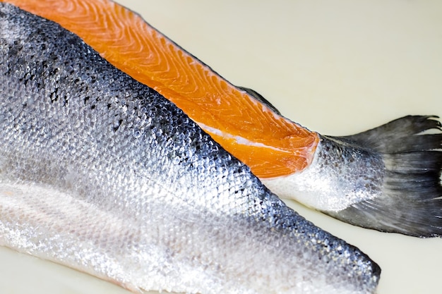 Vlees van vis zonder botten. Rauwe vis op beige achtergrond. Zalm gevangen in de zee. Ingrediënt voor salade of soep.