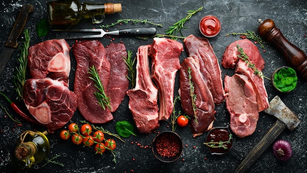 Vlees Verse rauwe kalfssteaks en vlees Bovenaanzicht Platliggend bovenaanzicht op zwarte stenen snijtafel