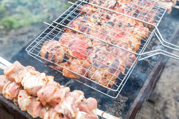 Vlees wordt gebakken op een grill op een grill in de natuur Outdoor picknick Selectieve focus Close-up