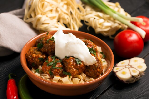 Vleesballen met tomatensaus en deegwaren, close-up