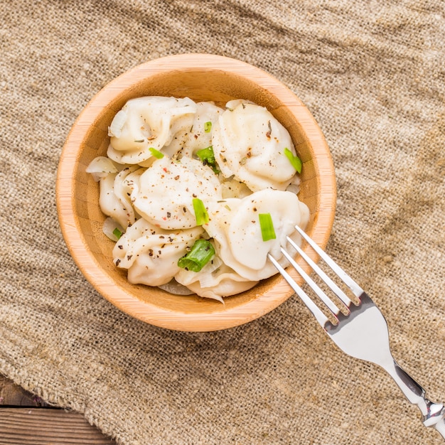 Vleesbollen - russische pelmeni, ravioli met vlees op een houten plaat