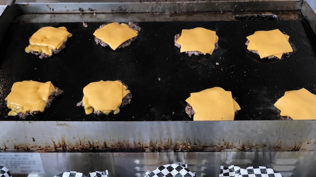 Foto vleespasteitjes met kaas op de grill om hamburger te maken