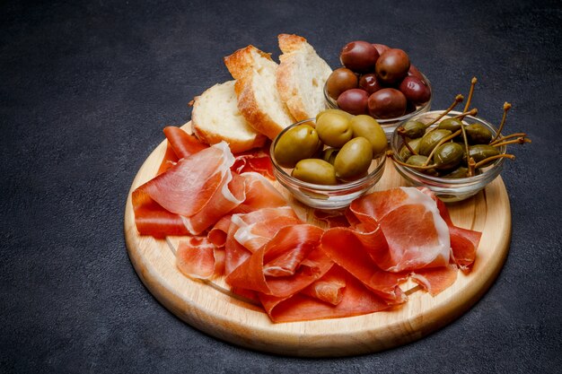 Vleesplaat van Italiaanse prosciuttocrudo of Spaanse jamon op houten scherpe raad