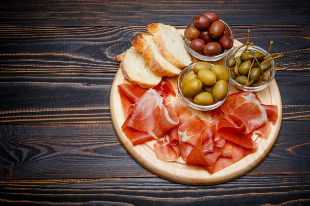 Vleesplaat van Italiaanse prosciuttocrudo of Spaanse jamon op houten scherpe raad