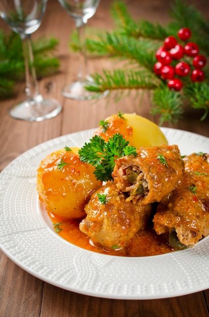 Foto vleesrolletjes gevuld met gerookt spek en ingelegde komkommer gestoofd in jus