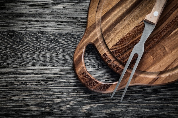 Vleesvork snijplank op hout achtergrond