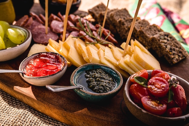 Vleeswaren snacks en garneren met ambachtelijke Parmezaanse kaas verse tomaten Duits zwart brood jam pestosaus komkommers groene druiven en groenten