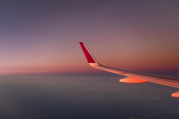 Vleugel van een vliegtuig in de lucht tijdens de zonsondergang