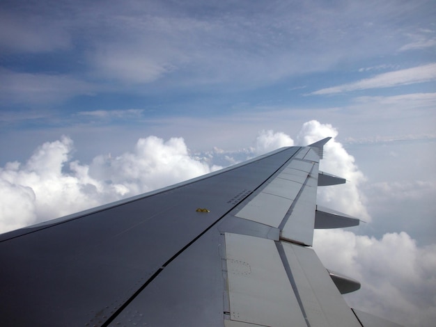 Foto vleugel van het vliegtuig tegen bewolkte lucht