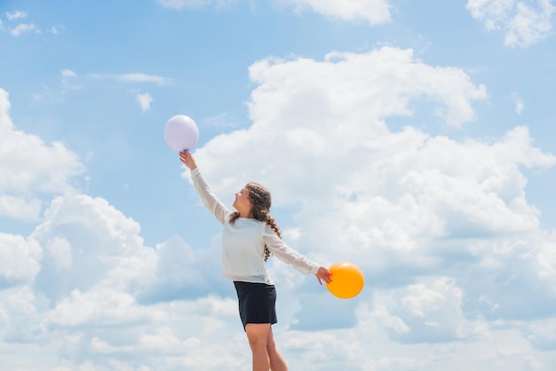 Vlieg met heliumballonnen Elke dag hoger en hoger Vrolijk meisje veel plezier Zomervakanties en vakantie Jeugd geluk Geluk concept Vrijheid concept Geluk is luchtballonnen