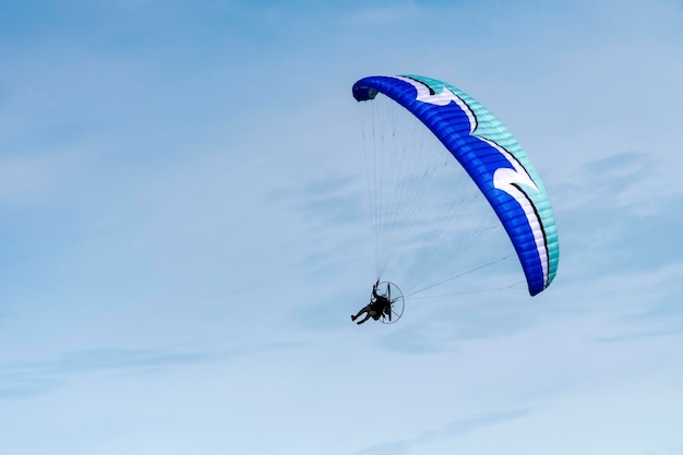 Vliegen met paramotor in de lucht op blauwe hemelachtergrond