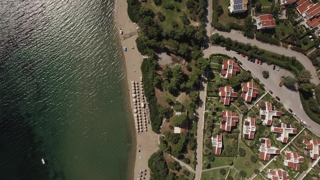 Vliegen over de zee en de kust met huisjes en groene werven ernaast. ligbedden aan de kust. wonen aan de kust. trikorfo-strand, griekenland