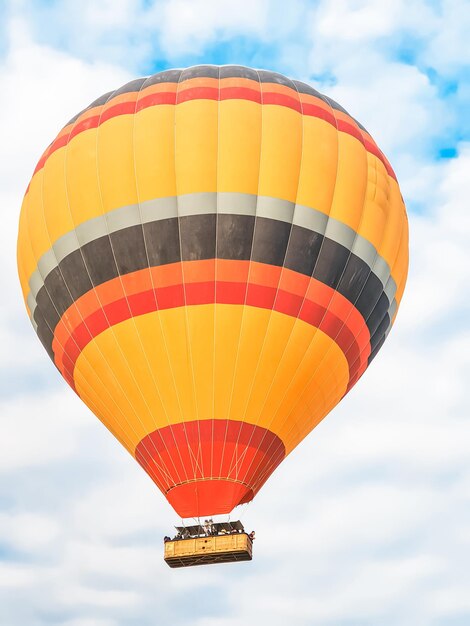 Foto vliegende in de lucht vele helder gekleurde prachtige ballonnen in de lucht in cappadocië in de bergen vroeg bij zonsopgang ochtend vullen ballon met warme lucht uit brander grote mand toeristen excursie wolk vlucht