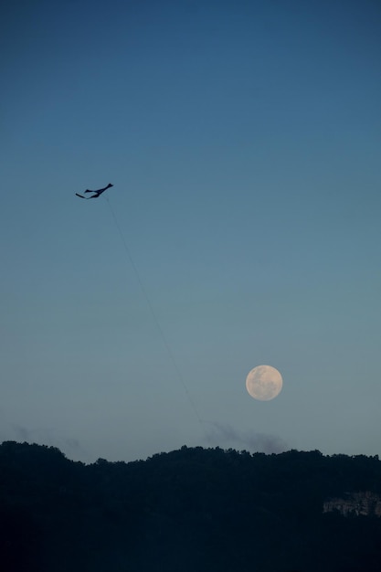 Foto vlieger en volle maan bij daglicht, supermaan in de zomer