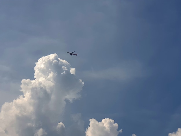 Vliegtuig dat over de wolken in de luchtachtergronden vliegt