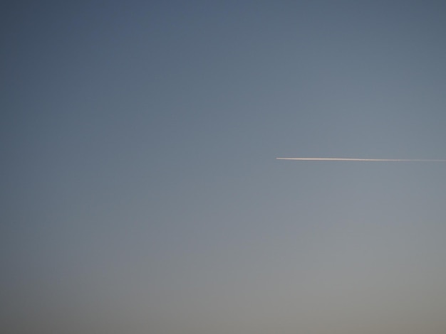 Vliegtuig en spoor in de avond hemelsblauw Abstracte achtergrond op een ruimte- of aero-thema Kleurverloop