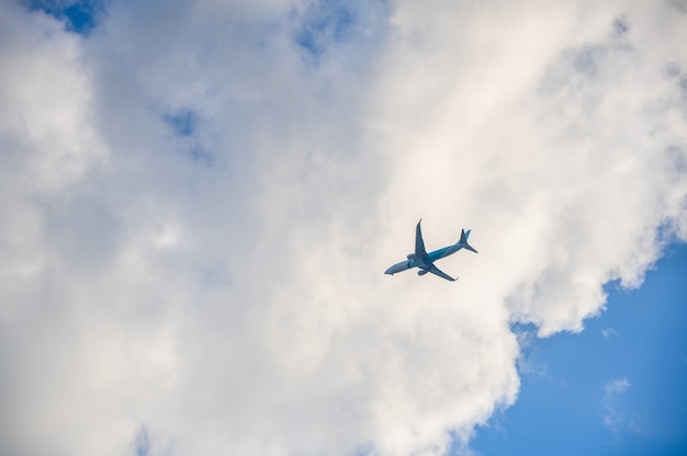 Vliegtuig in de blauwe lucht en de wolken.