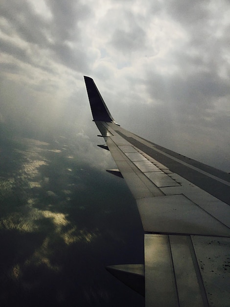 Vliegtuig op weg tegen bewolkte lucht
