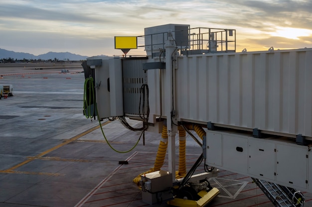 Vliegtuig opstijgen in de rode zonsondergang in de instapbrug die wordt gebruikt om de luchthaven te verbinden