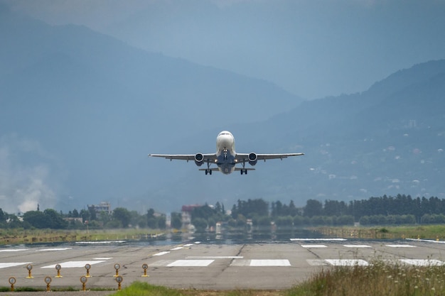 Vliegtuig opstijgen vanaf de luchthaven bergen op achtergrond vervoer concept