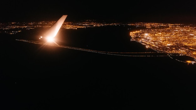 Vliegtuig raam uitzicht op vleugel gloeiende avond stad nacht reisconcept