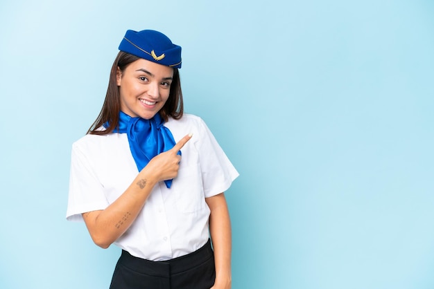 Foto vliegtuig stewardess blanke vrouw geïsoleerd op blauwe achtergrond wijzend naar de zijkant om een product te presenteren