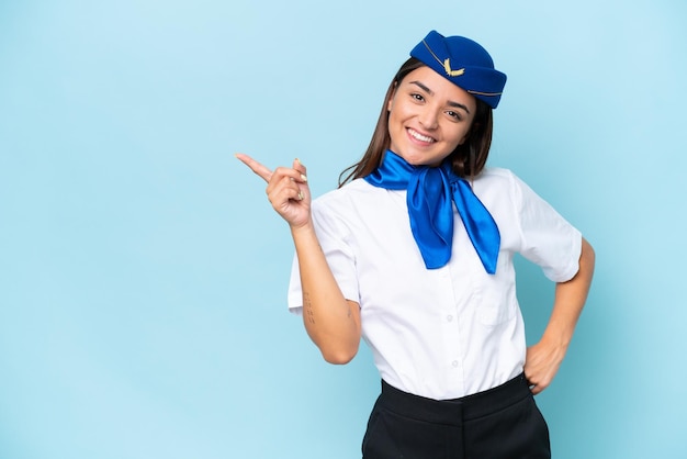 Vliegtuig stewardess blanke vrouw geïsoleerd op blauwe achtergrond wijzende vinger naar de zijkant