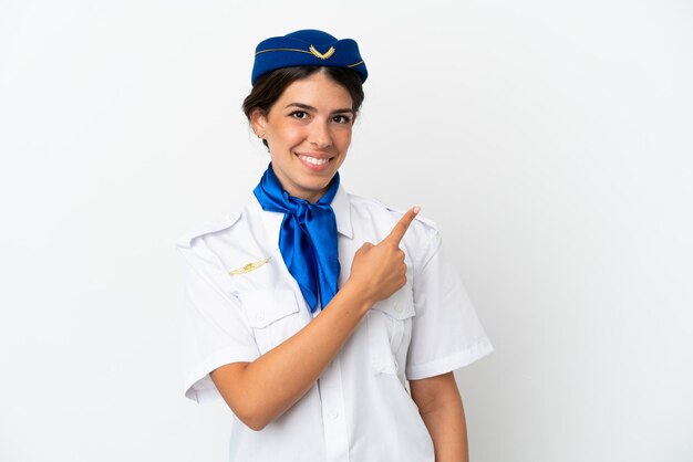 Vliegtuig stewardess blanke vrouw geïsoleerd op een witte achtergrond wijzend naar de zijkant om een product te presenteren
