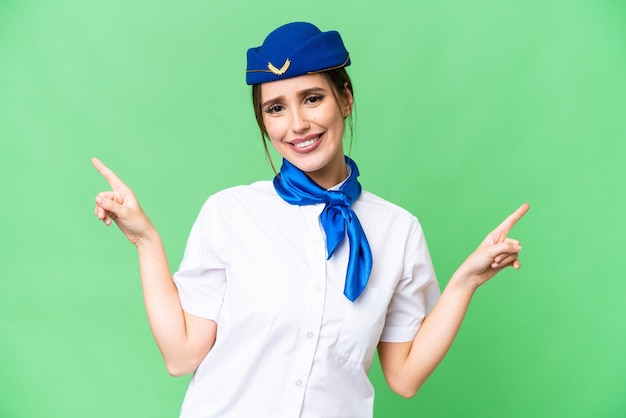 Vliegtuig stewardess over geïsoleerde chroma key achtergrond wijzende vinger naar de zijtakken en gelukkig