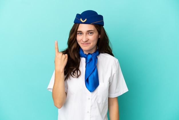 Vliegtuig stewardess vrouw geïsoleerd op blauwe achtergrond wijzend met de wijsvinger een geweldig idee