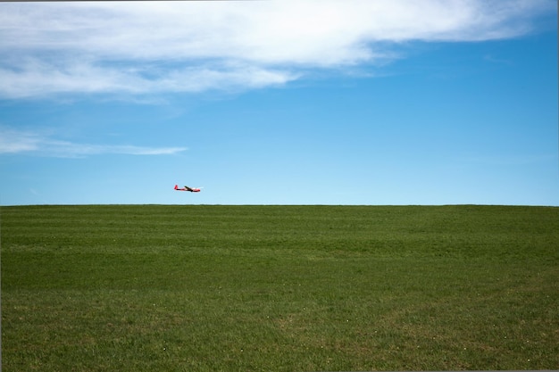 Vliegtuig vliegt over een groen landschap tegen de lucht