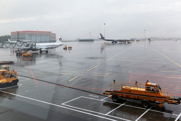 Vliegtuigen en dienstvoertuigen op het vliegveld op een bewolkte dag Moskou Rusland 102620221