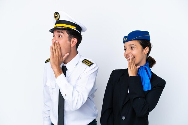 Foto vliegtuigpiloot en gemengd ras stewardess geïsoleerd op een witte achtergrond schreeuwen met de mond wijd open naar de laterale