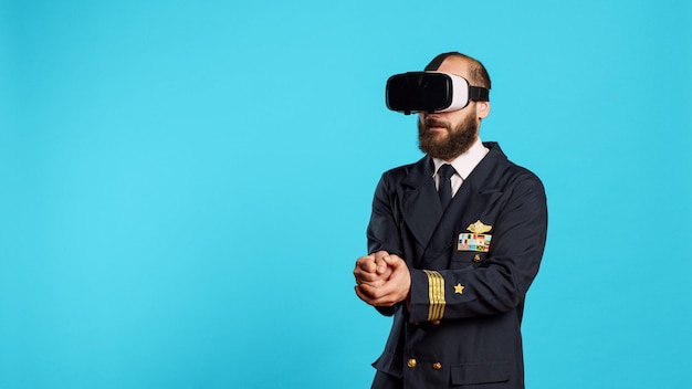 Vliegtuigpiloot met behulp van vr-headset met interactieve visie, plezier maken met virtual reality-bril. Jonge kapitein van een luchtvaartmaatschappij met luchtvaartuniform met behulp van 3D-simulatiegadget, vliegtuigbemanning.