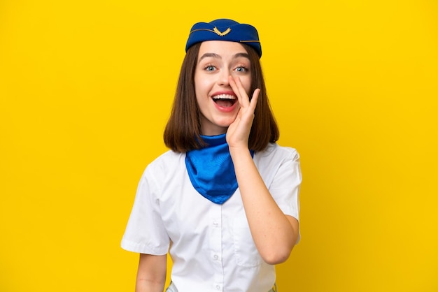Vliegtuigstewardess Oekraïense vrouw geïsoleerd op gele achtergrond met verrassing en geschokte gezichtsuitdrukking