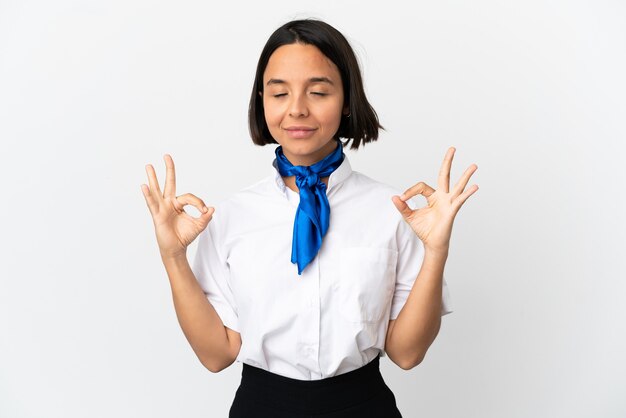 Vliegtuigstewardess over geïsoleerde achtergrond in zen pose