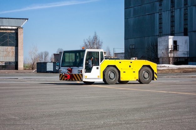 Vliegtuigtrekker beweegt naast de hangars