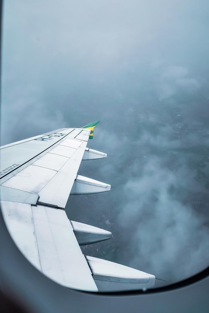 Vliegtuigvenster met zicht op de wolken