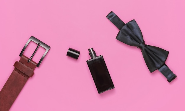 Vlinderdas riem parfumflesje op roze achtergrond Heren accessoires heren zakelijke stijl set Formele stijl voorbereiding voor de bruiloft