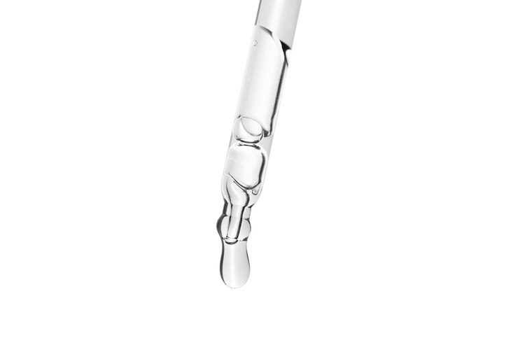 Foto vloeibare druppel uit laboratoriumglas pipetteer op witte achtergrond met uitknippad