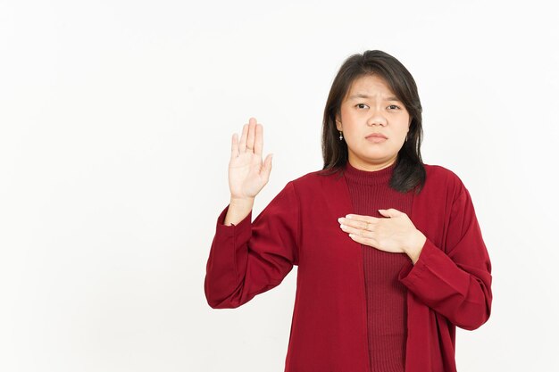 Vloeken of belofte gebaar van mooie Aziatische vrouw, gekleed in rood shirt geïsoleerd op een witte achtergrond