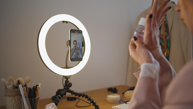 Photo vlogger hands demonstrating cosmetics at studio closeup woman filming tutorial